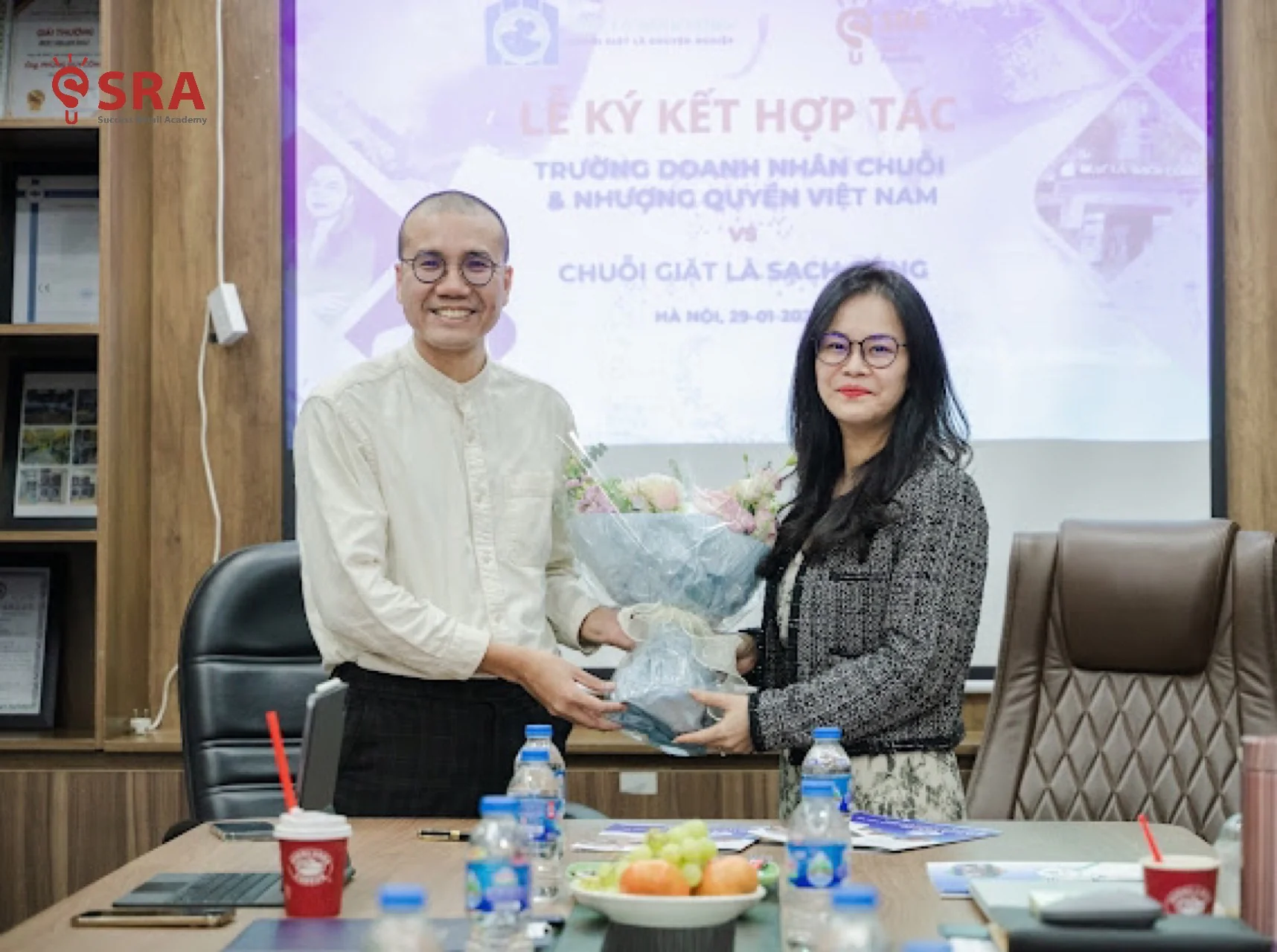 Bà Trần Thị Hà (Giám đốc tài chính của chuỗi Giặt Là Sạch Cộng) tặng hoa HLV Thích Nhân Chuỗi sau lễ ký kết