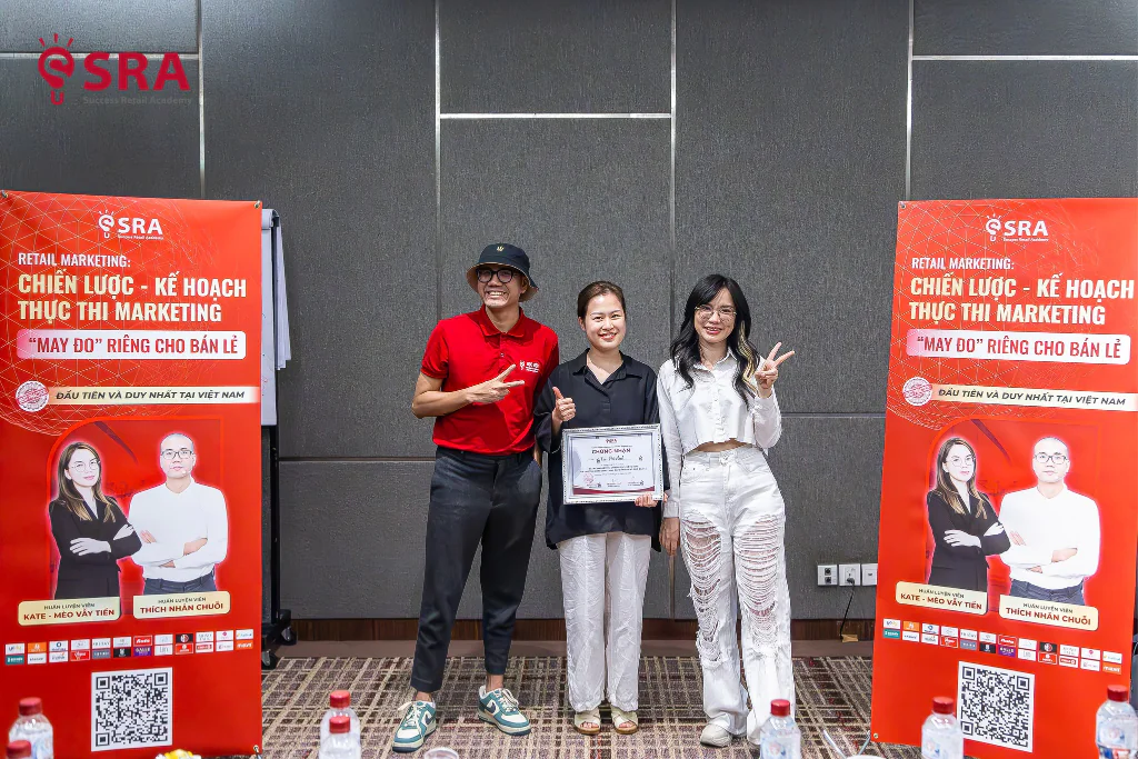 Học viên nhận chứng nhận trước backdrop khoá Retail Marketing của Trường SRA