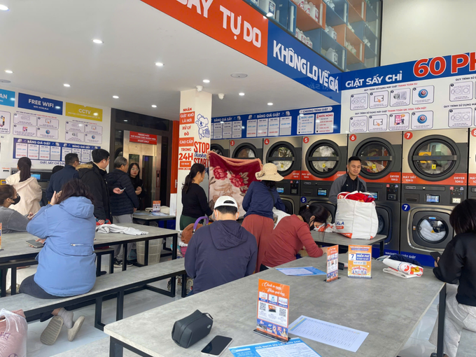 Khách hàng chờ giặt sấy tại cửa hàng. Ảnh: Koalala